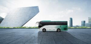 A modern bus parked in front of a scenic view in Ajman, highlighting the convenience and luxury of bus rental services in the city.